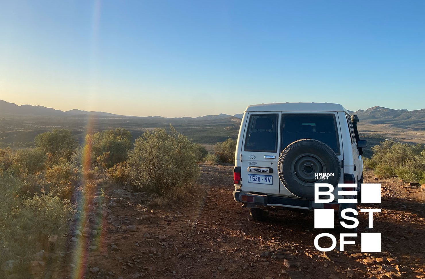 a troop carrier parked on a hill at sunset