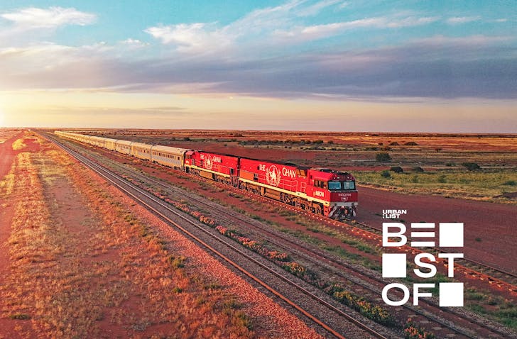 a train driving through the desert at sunset