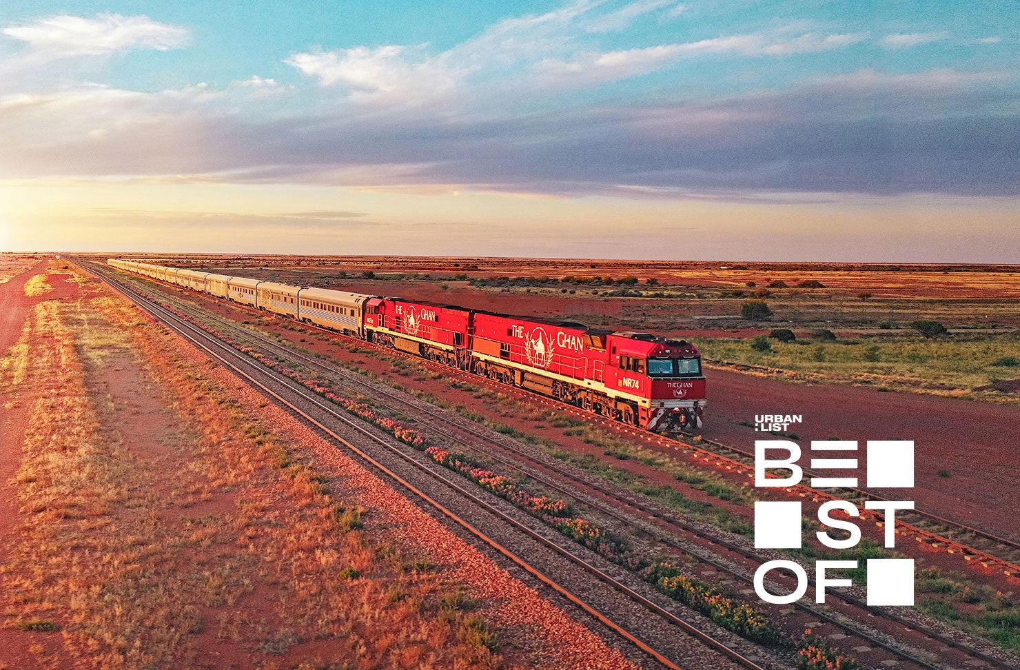a train driving through the desert at sunset