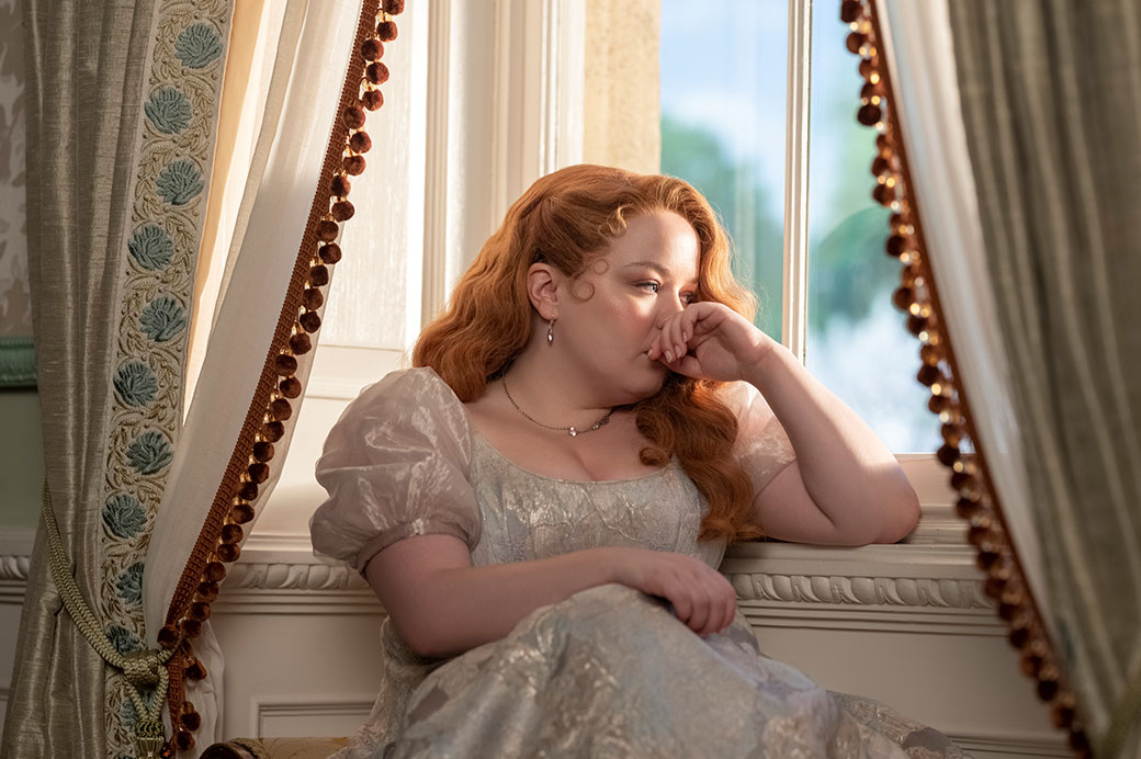 a person wearing period clothing leaning on a window sill