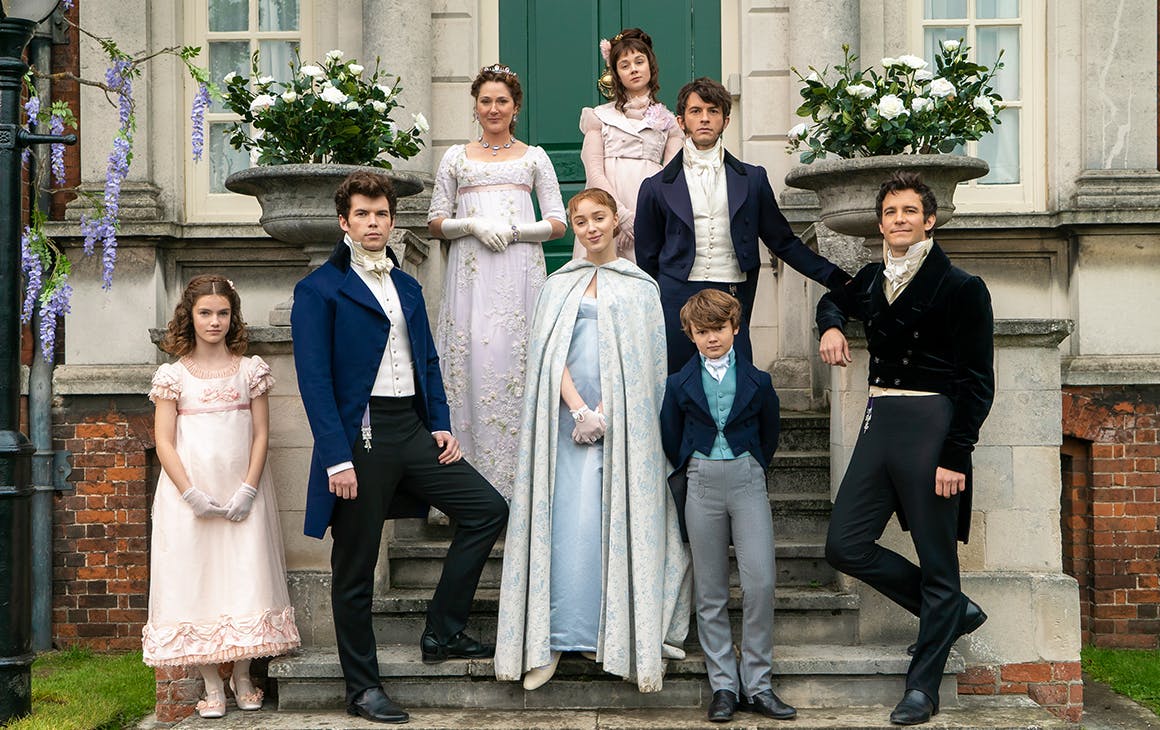 The cast of the Bridgerton family pose on steps outside a stately house