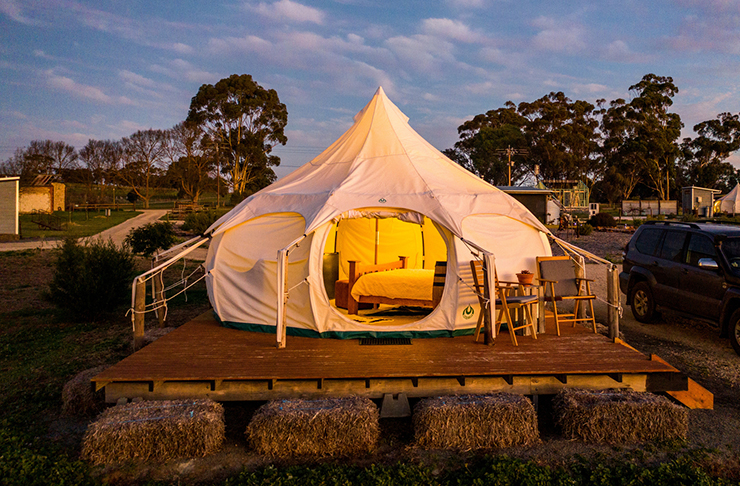 glamping style tent on deck with hay on a farm