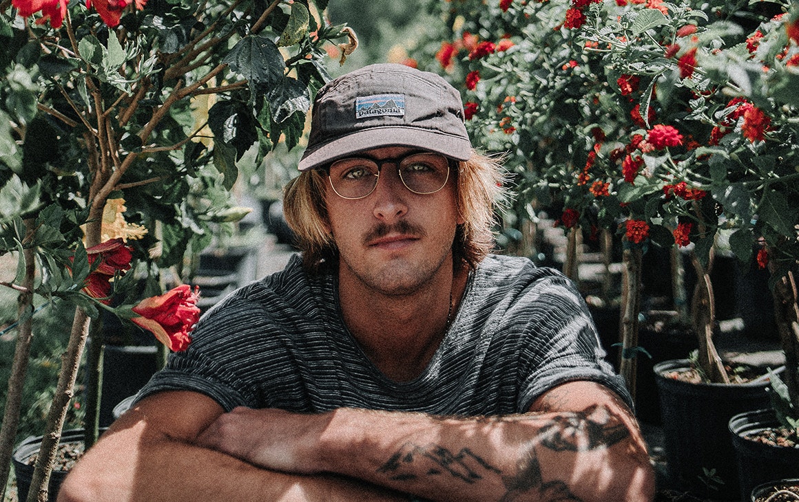 a man sits in the middle of a flower bush