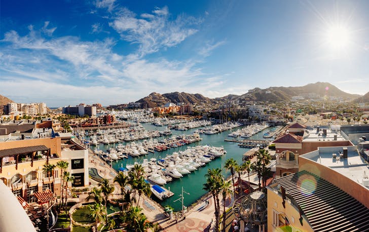 Cabo Bay with a brilliant blue sky and a marina lined with boats.