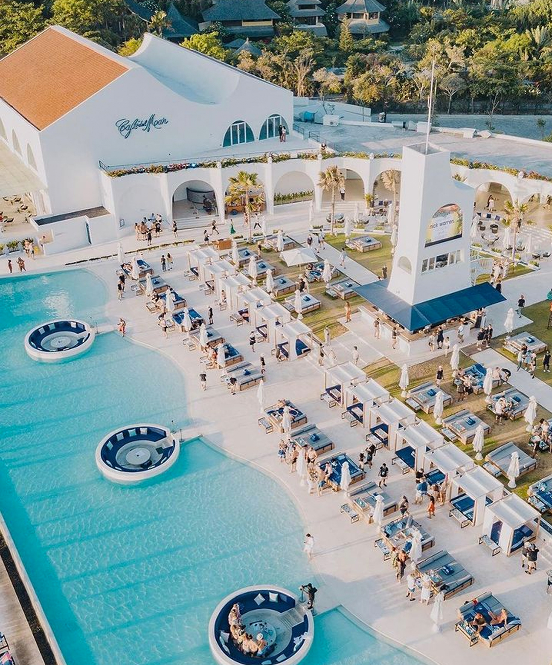 a slick beach club with cabanas and a giant pool