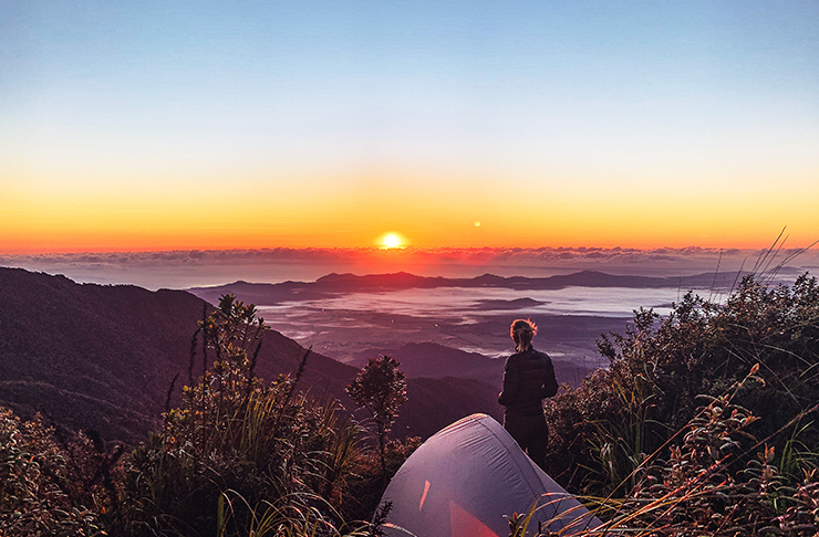 personne campant au sommet de la montagne au lever du soleil