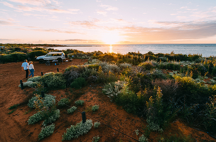 voiture garée au terrain de camping de la côte au coucher du soleil