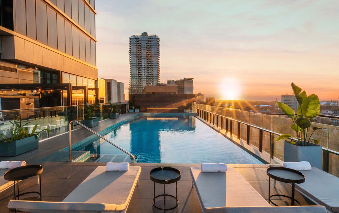 The rooftop pool at sunset of Crowne Plaza