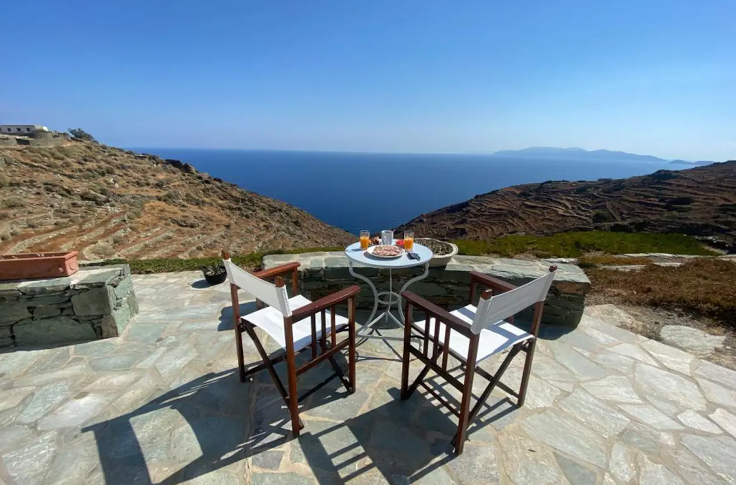 a table and chair overlooking a greek island