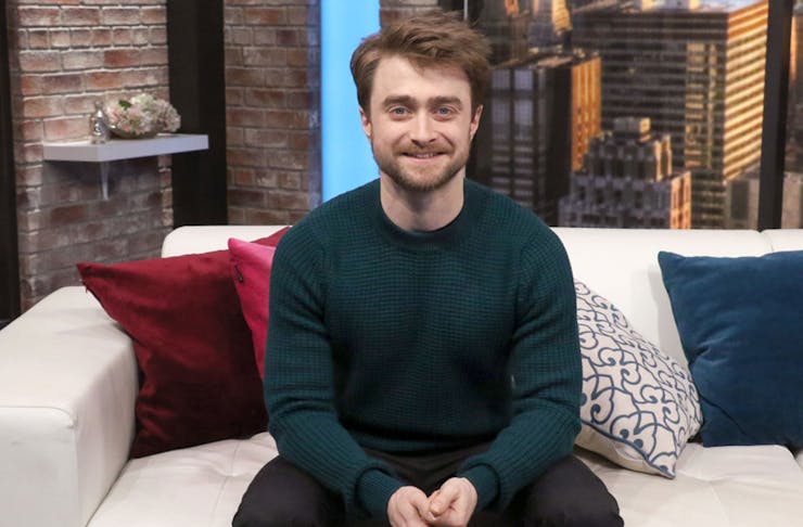 Daniel Radcliffe sitting on a sofa.
