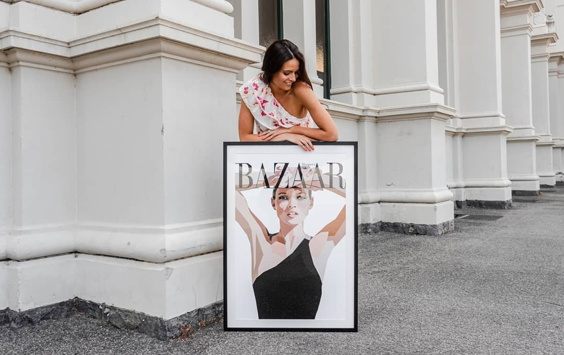 Artist Dom Gauci poses with a piece of art on the side of a street.