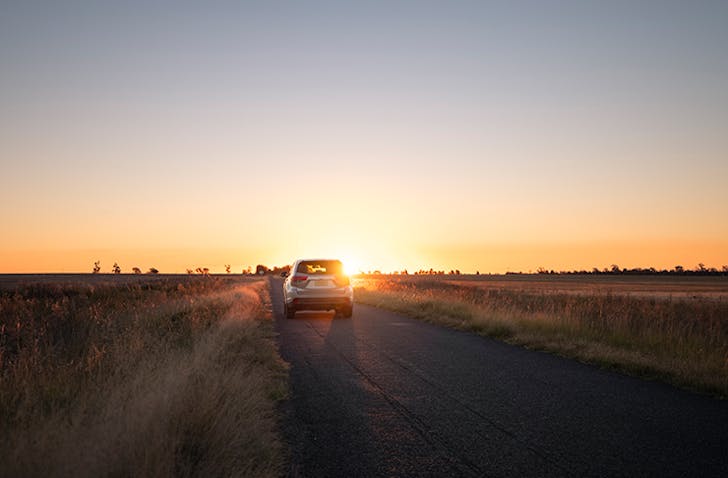 car driving into the sunset