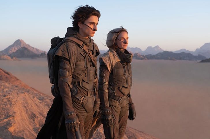 two people standing and overlooking a desert