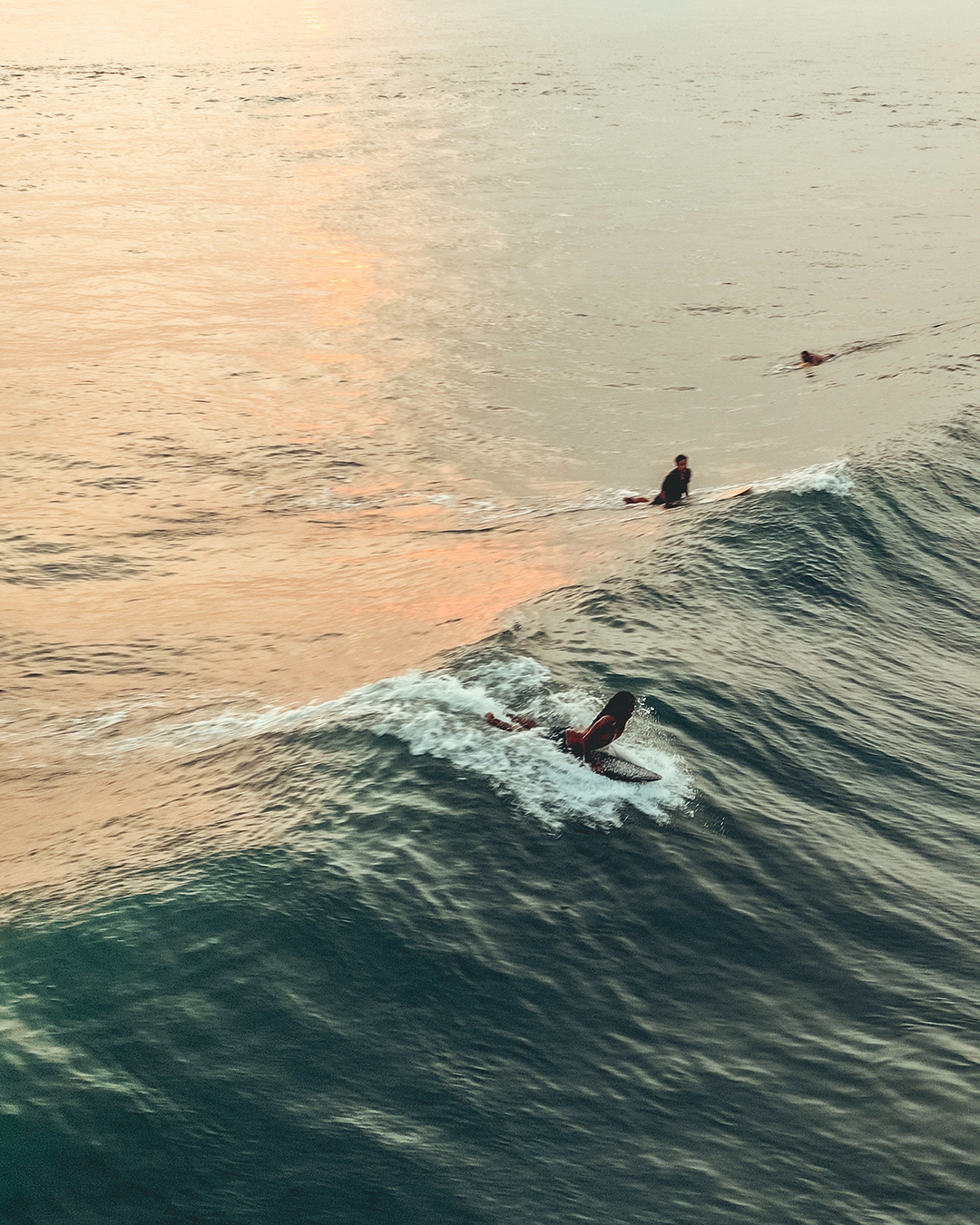 a person popping up on their surfboard on a wave