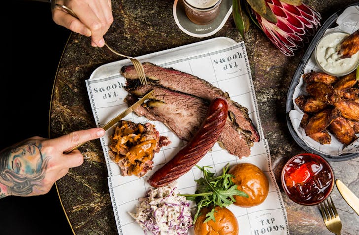 sliced smoked meats on meat trays on a marble table