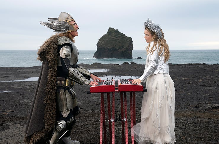 will ferrell and rachel mcadams dressed up as vikings playing piano on a volcanic ridge in Netflix's movie eurovision song contest the story of fire saga
