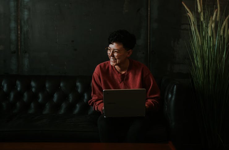 girl sitting on couch with laptop