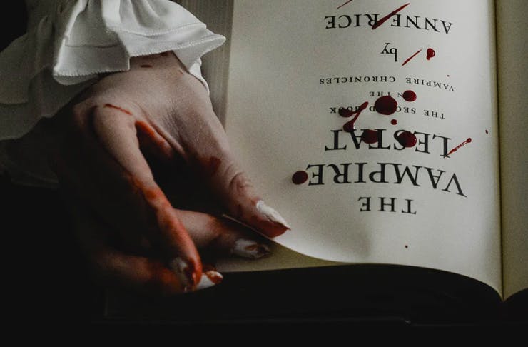 bloody hand turning page of book