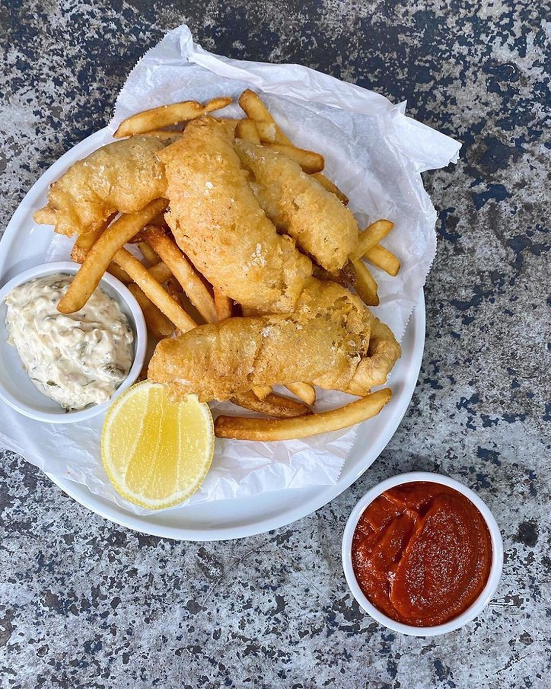 plate of fish and chips with tomato sauce