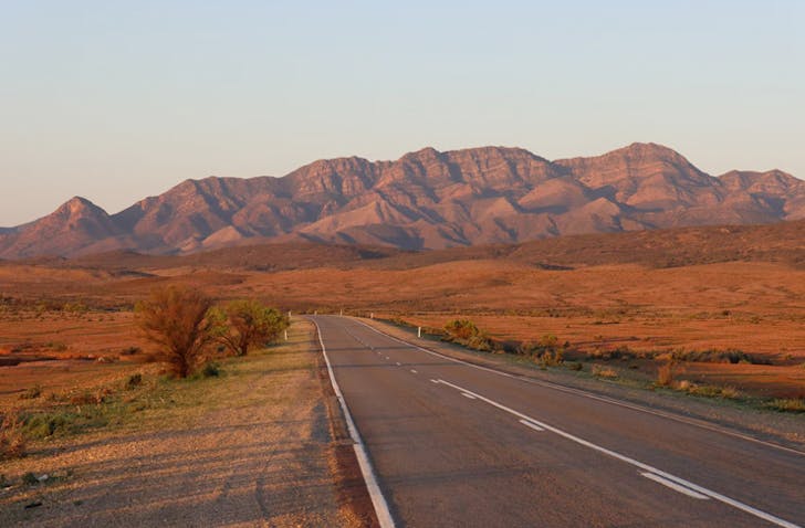 road leading into mountains at sunset