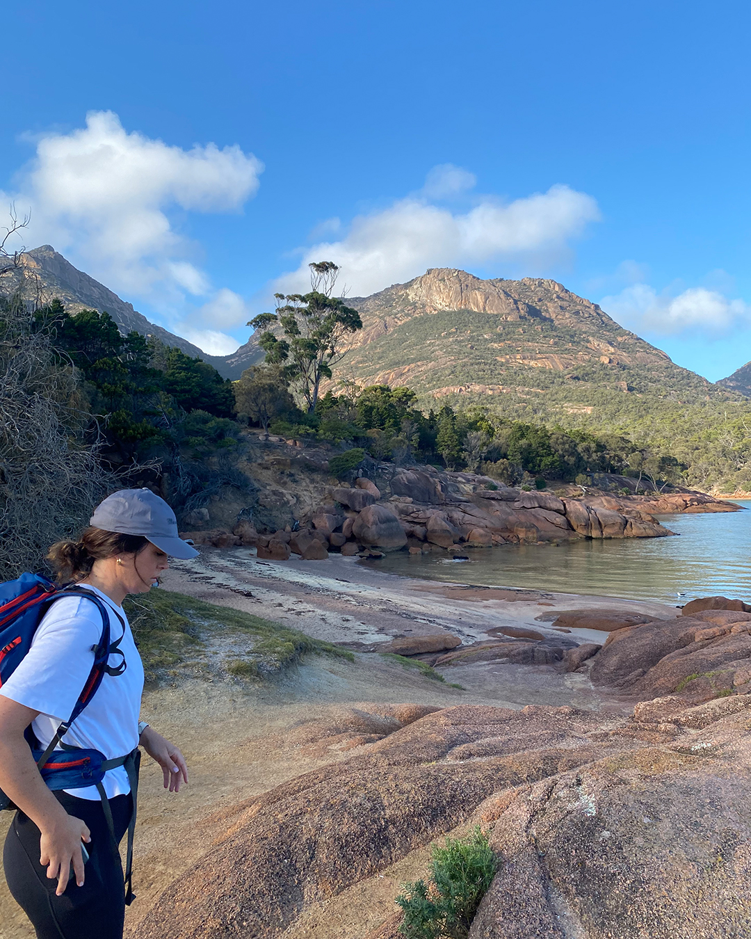 a person wearing a hiking bag and walking by the shoreline