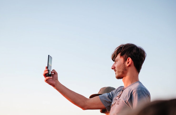 man holding phone to the sky