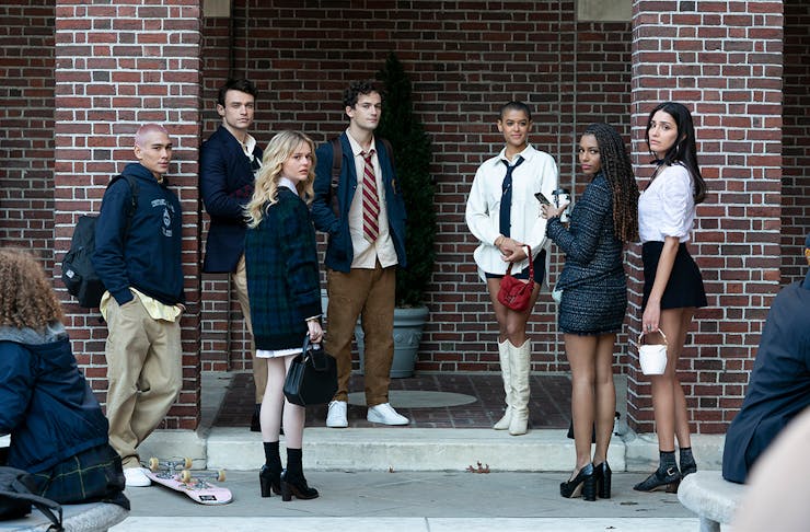 The cast of the Gossip Girl reboot stand on the steps of a brownstone building in New York
