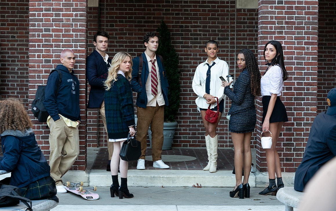 The cast of the Gossip Girl reboot stand on the steps of a brownstone building in New York