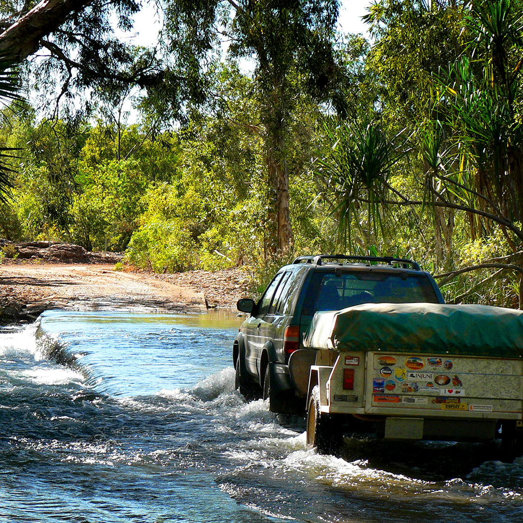 Four-wheel drive vehicle crossing a low causeway on the Gregory River during the dry season, Near Boodjamulla National Park, Gulf Country, Queensland, Australia.