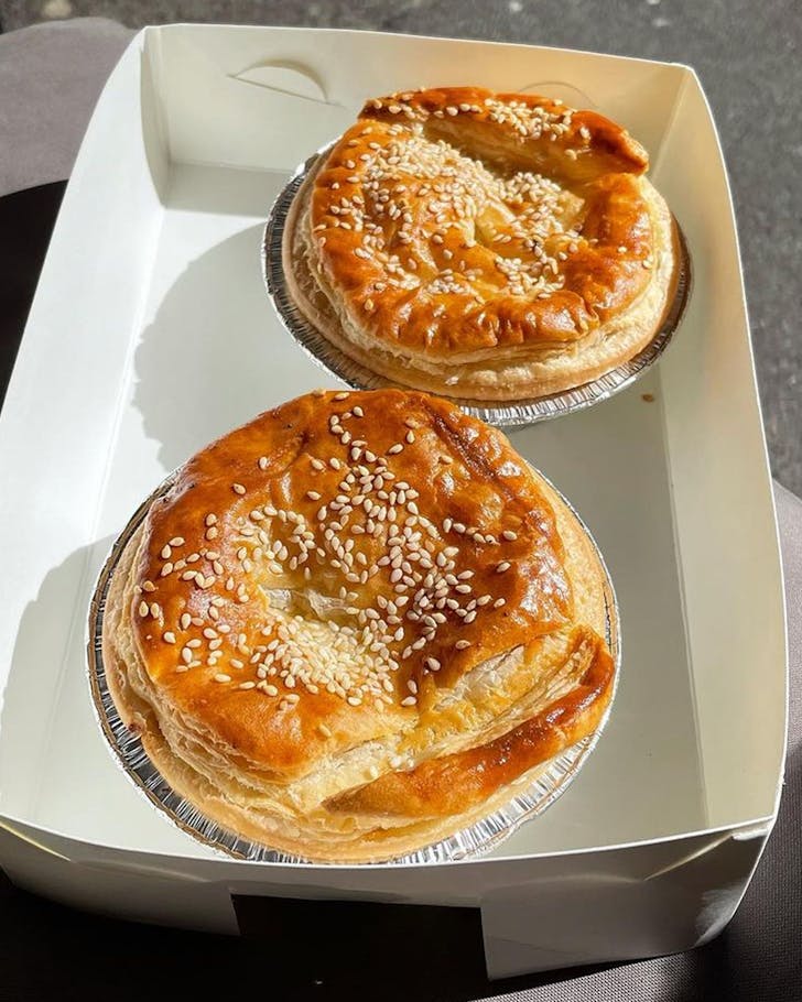 two crispy pies in a paper takeaway box in the sun