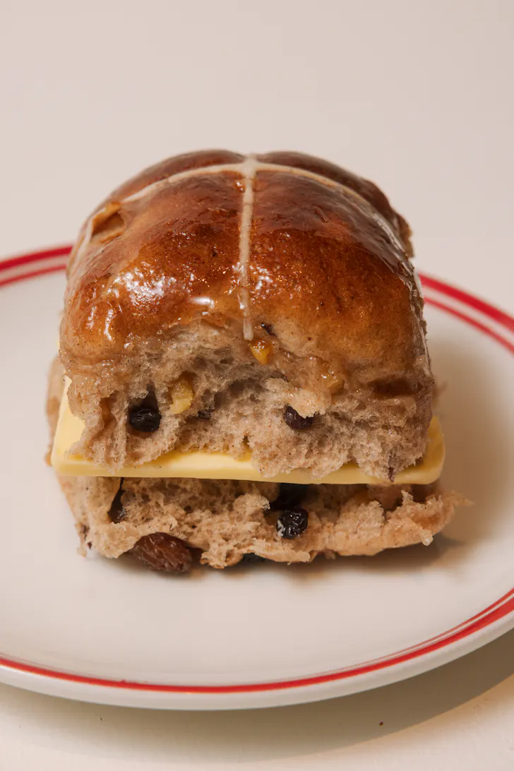 a hot cross bun with a slab of butter in the centre