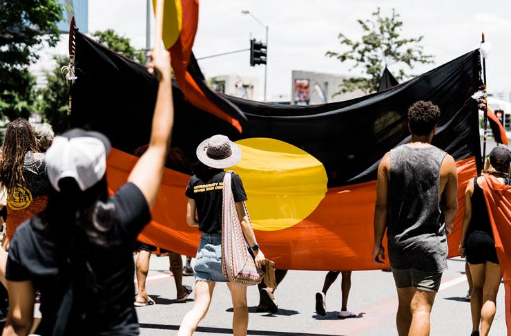 people walking in the street, protesting 'australia day'