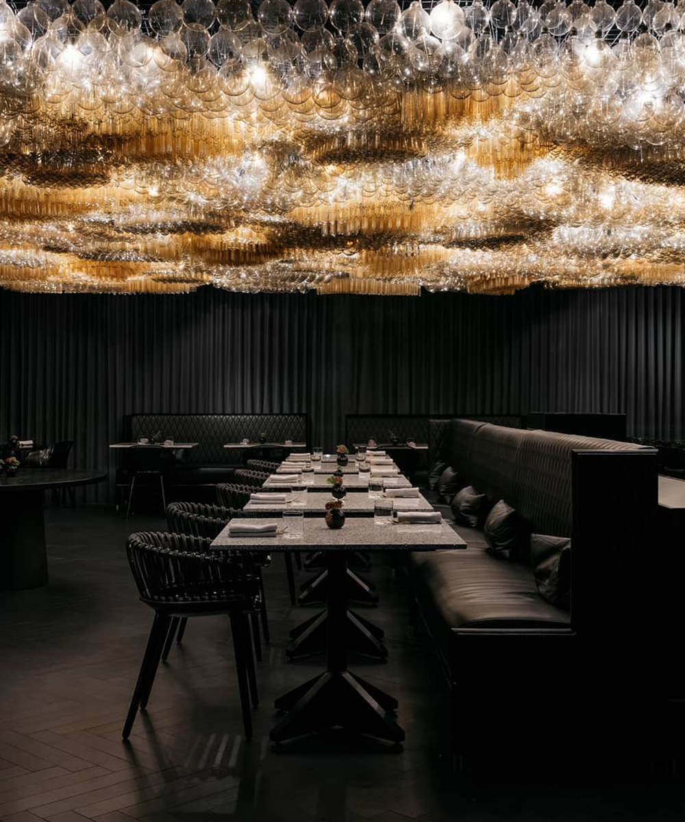 a cluster of stunning lights above an all black dining room