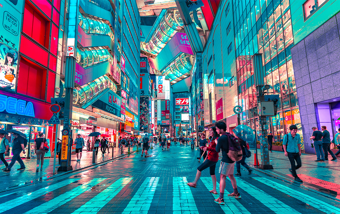 a vibrant night scene in downtown tokyo filled with bright, colourful buildings and bustling with tourists.