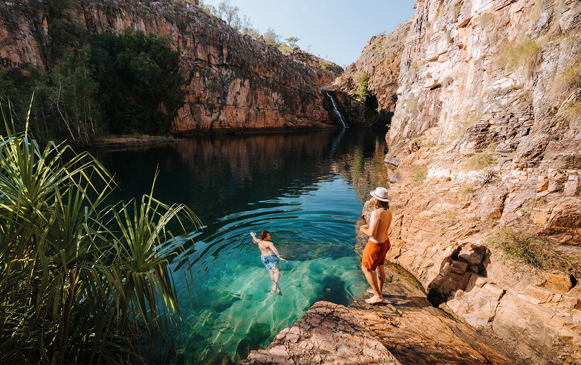 people swim in sparkling blue waters at Kakadu