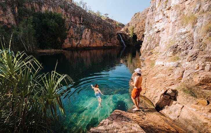 people swim in sparkling blue waters at Kakadu