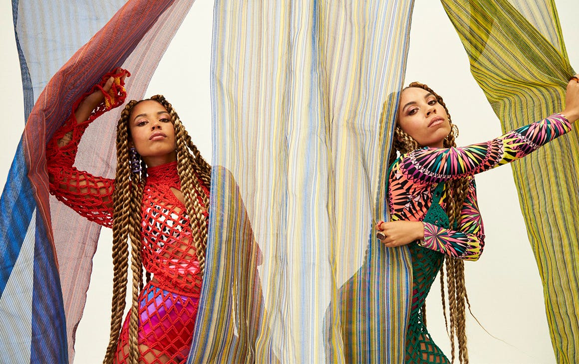 Kinder, peek out from behind sheer, colourful curtains.
