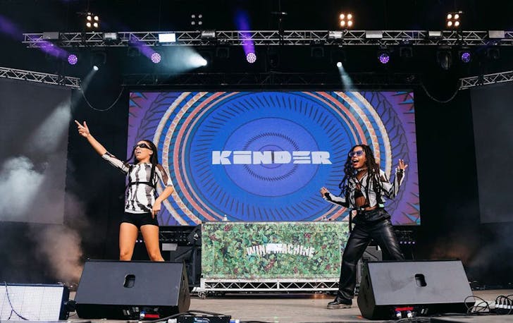 Kinder dance around the stage as they perform at a festival