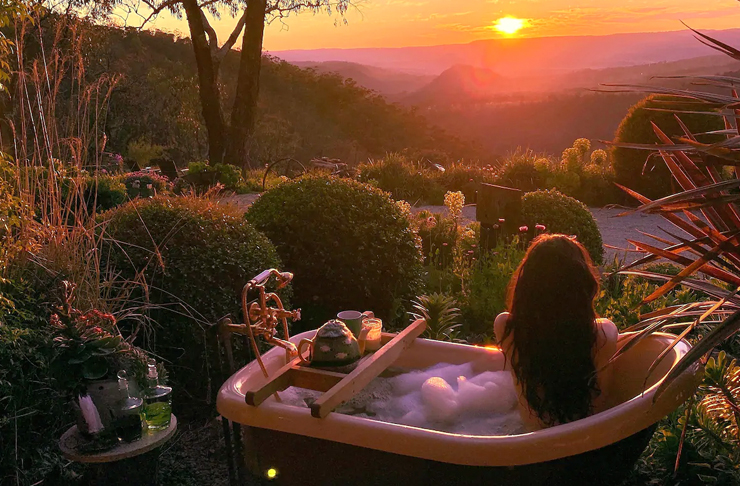 girl soaking in bath tub overlooking mountains