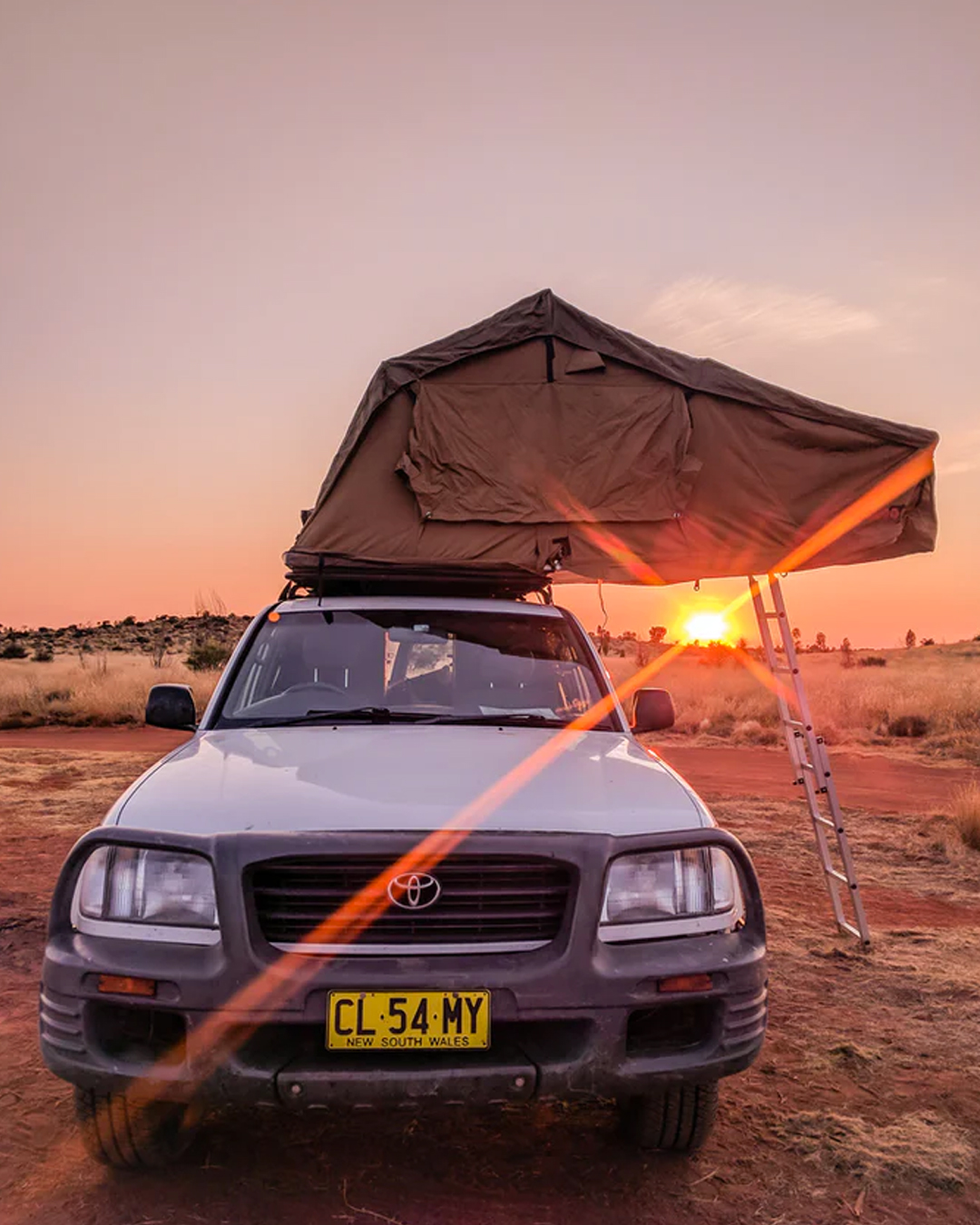 four wheel drive with overhead camping set up at sunset in Australian outback