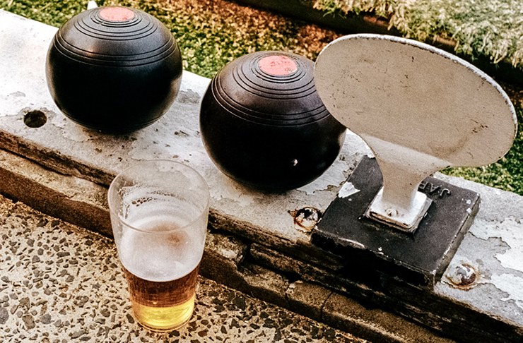 two lawn bowls and a schooner of beer