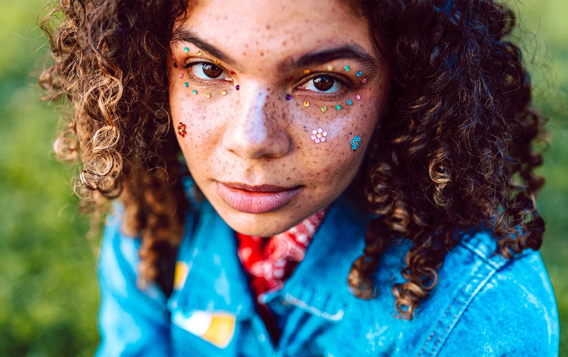 a close up image of a woman with glitter on her face.