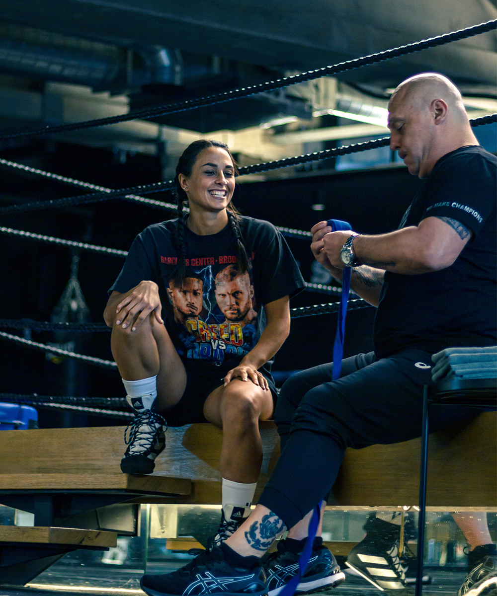 Linn Sandstrom sits on the edge of boxing ring with her trainer