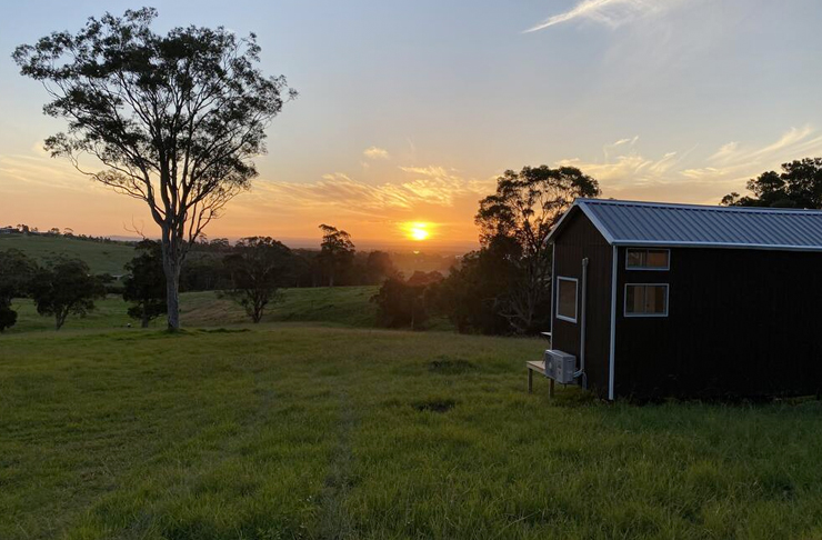 tiny home on hill at sunset