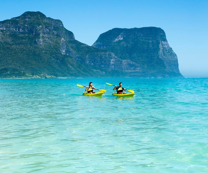 two people kayaking on crystal clear water