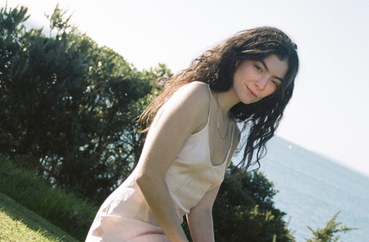 young woman with long brown hair posing on grass