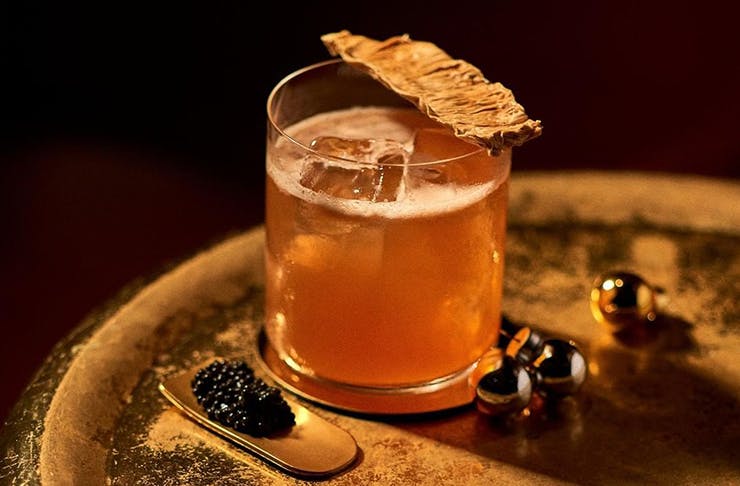 A decadent cocktail sitting on a table with caviar surrounding it.