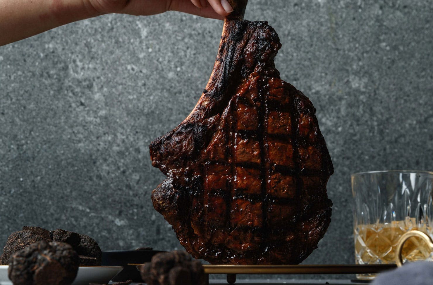 a person holding a perfectly cooked cut of meat