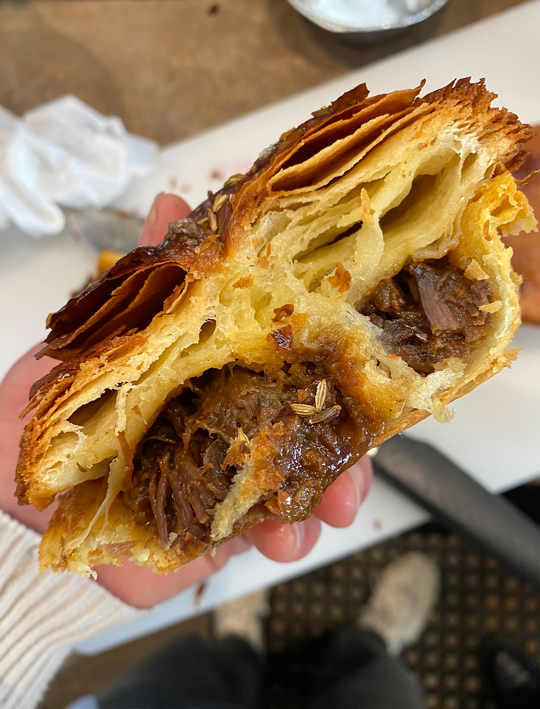cut through of meat mie croissant with seven hour slow cooked beef
