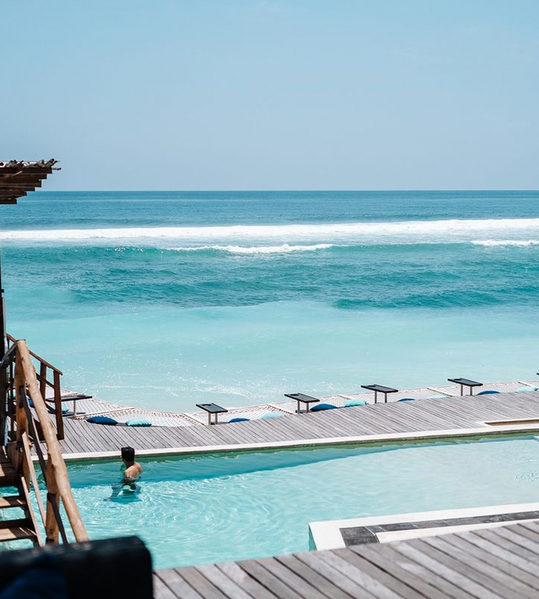 a person wading in an infinity pool